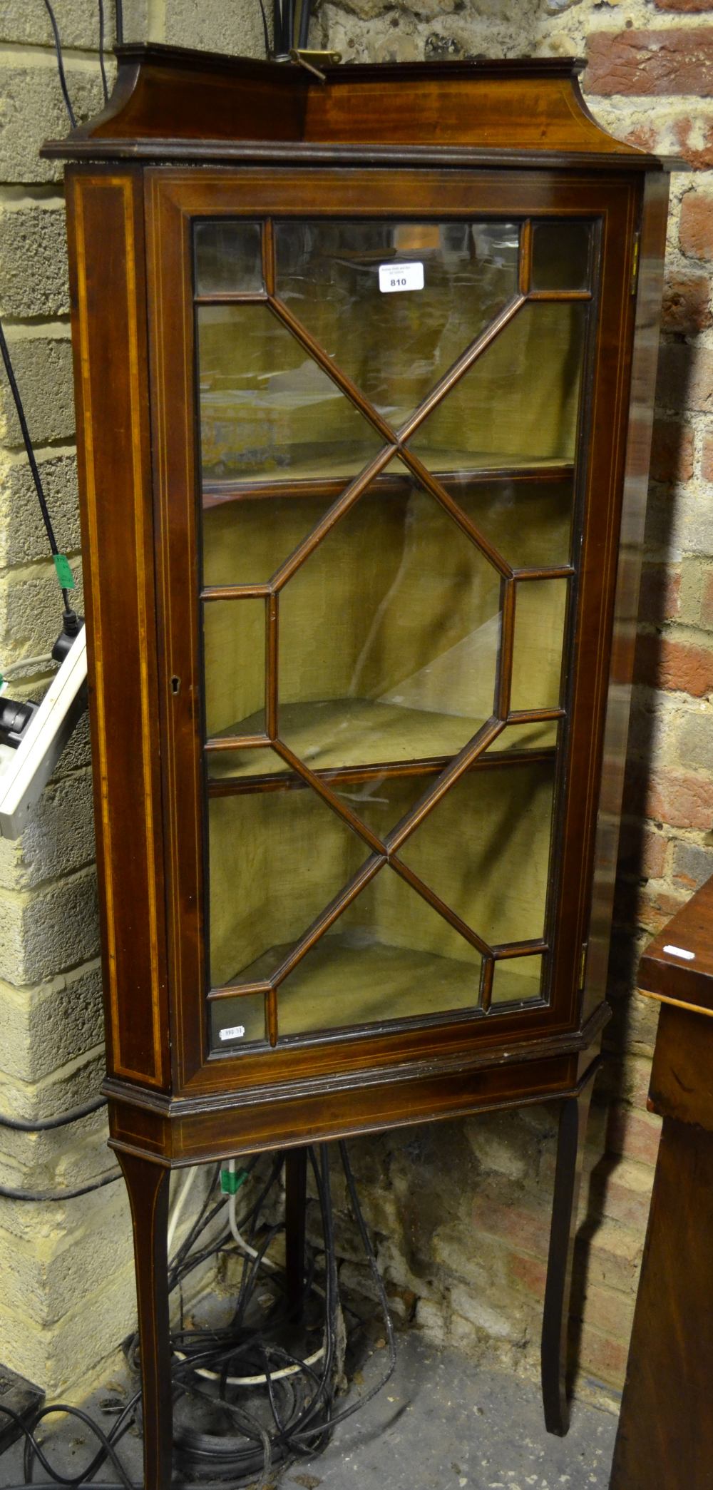 A Sheraton Revival satinwood inlaid walnut astragal glazed corner display cabinet raised on