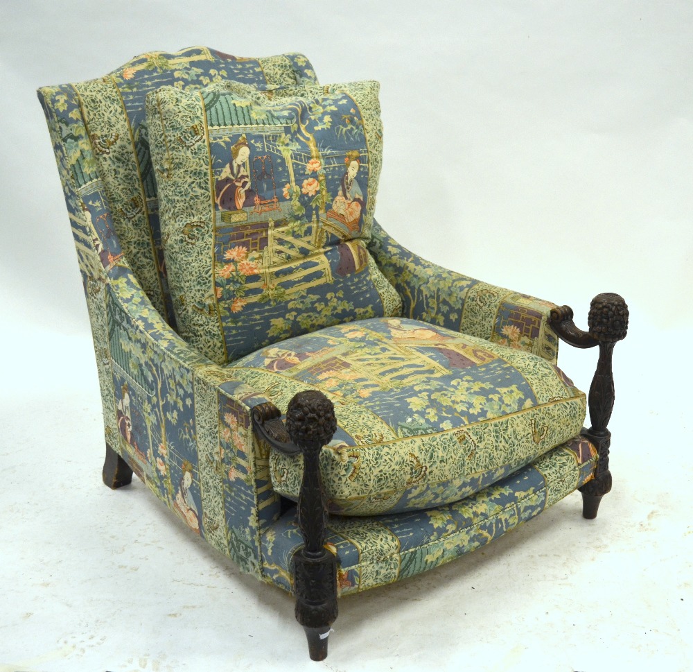 A 19th century Indian armchair, the well carved arm supports to the front legs, upholstered in