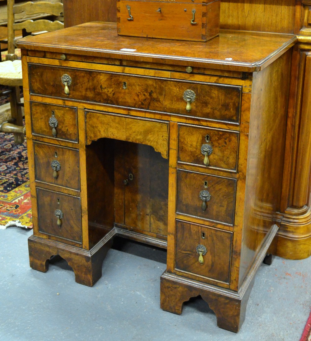 A George II style walnut kneehole desk, the top with fine moulded edge over a full width slide and