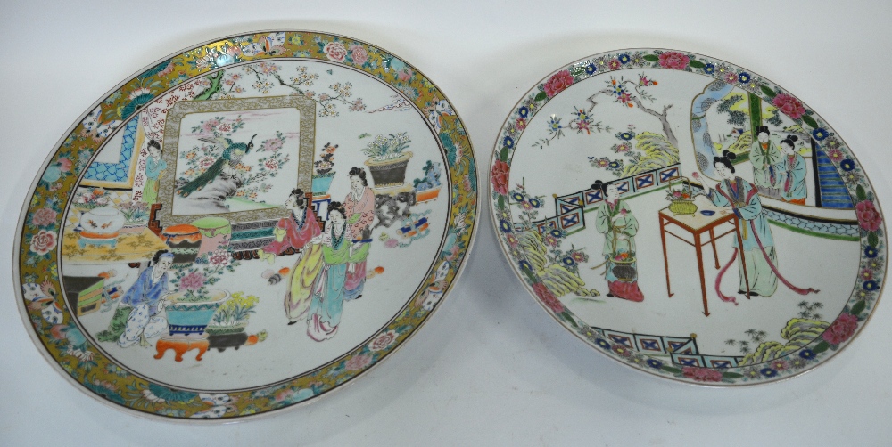 A Japanese famille rose charger decorated with figures in a garden within a gilt border decorated