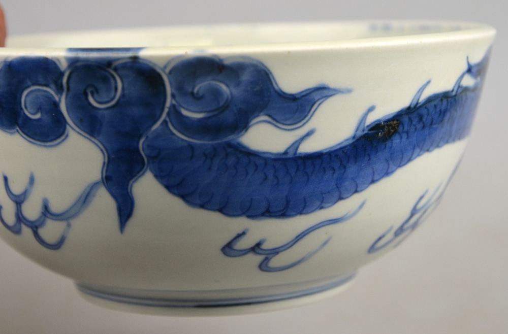 A Chinese 19th century heavily potted porcelain blue and white bowl decorated with a dragon - Image 3 of 5