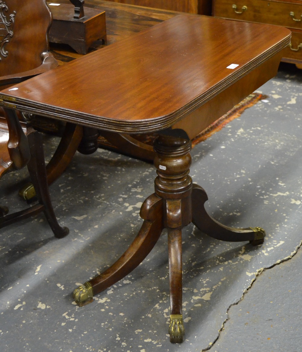 A Victorian mahogany tea table, the demi-lune fold over top raised on a turned support to quad sabre