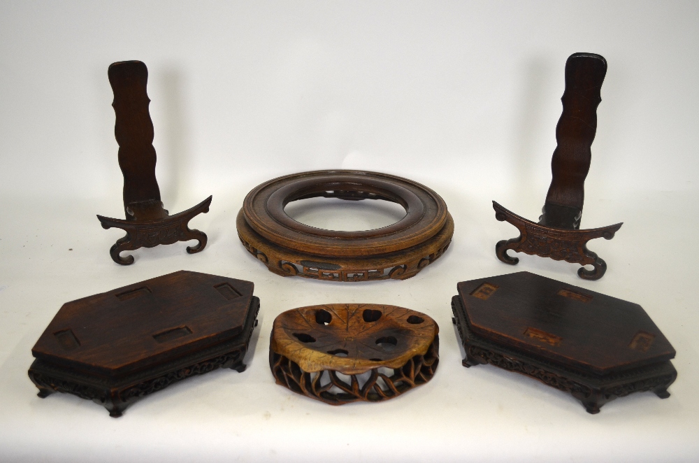 A pair of Chinese hardwood incense burner stands, two hardwood plate/charger stands, a large