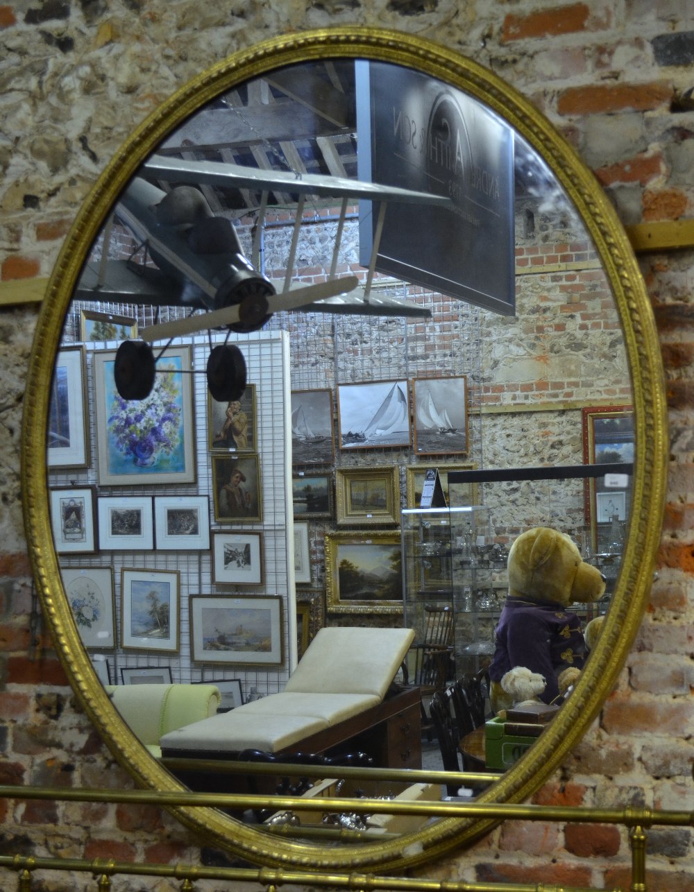 An oversize Victorian gilt framed mirror, the original oval plate within a well formed frame, 188