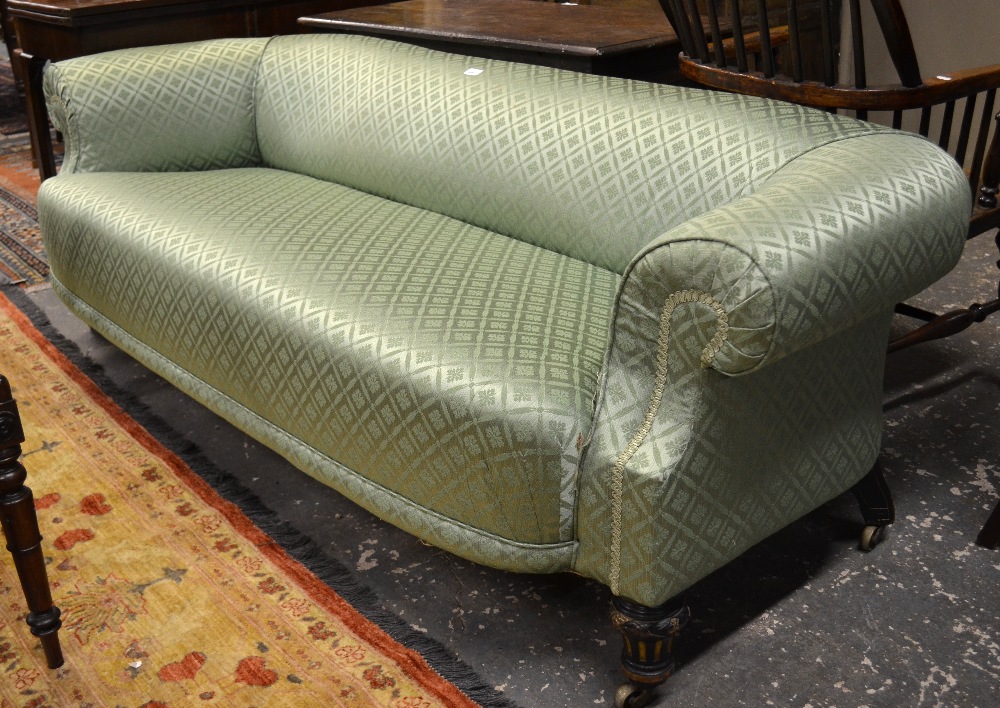 A late 19th century patterned green upholstered sofa, raised on short turned and reeded front legs