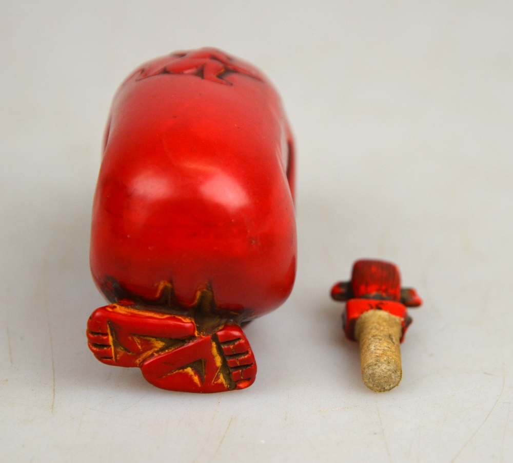 A Chinese red coloured hardstone snuff bottle and stopper in the form of a monkey, 8.5 cm - Image 3 of 3