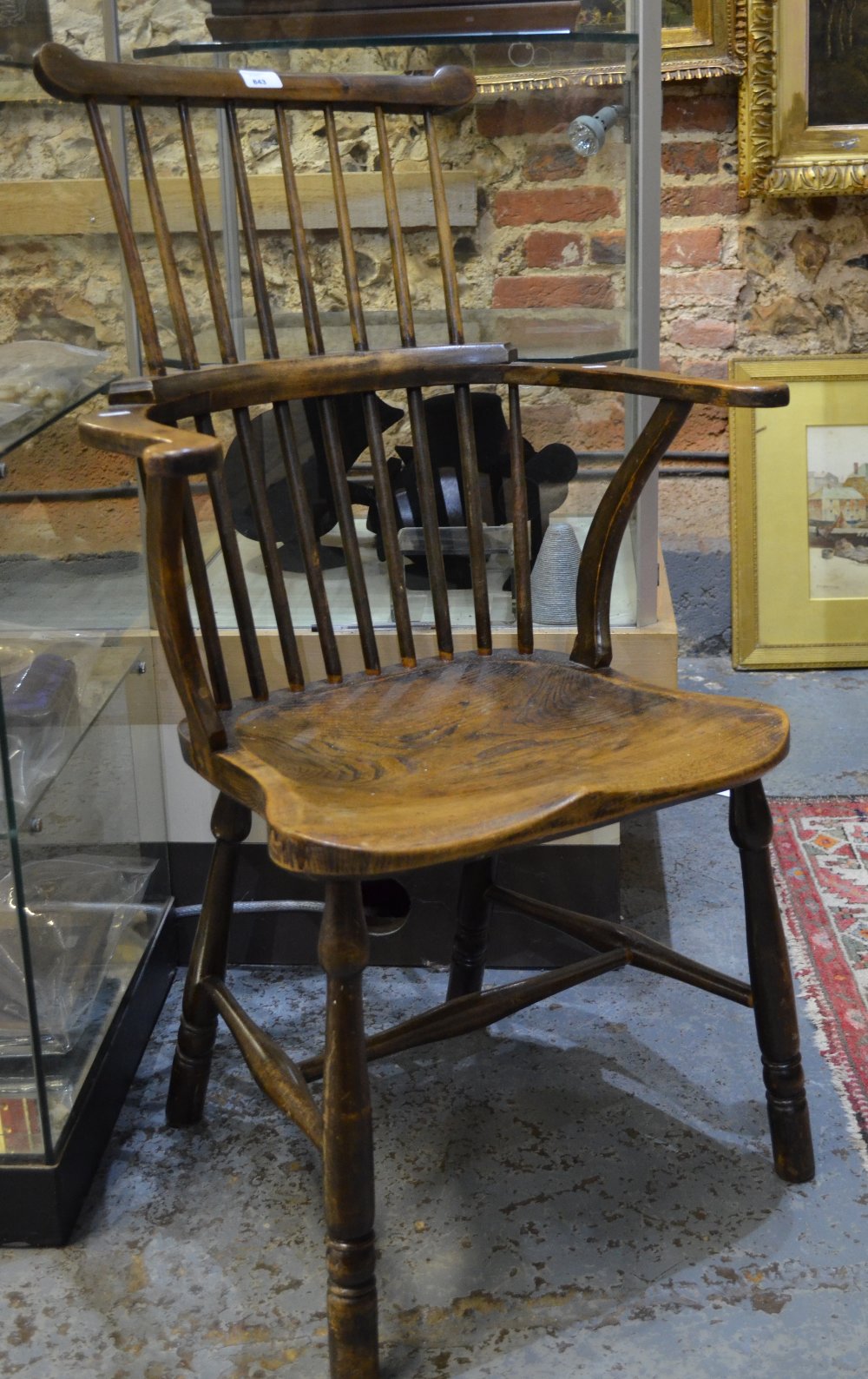 A 19th century elm seat stick back elbow chair