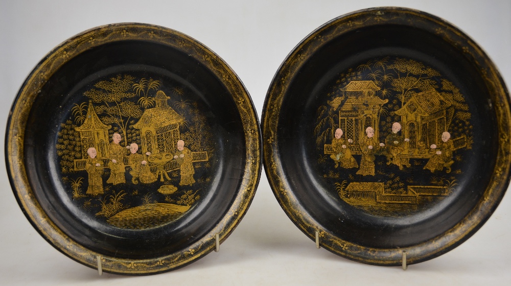 A pair of Chinese black lacquer bowls decorated with gilt figures on a terrace, 20th century, 21