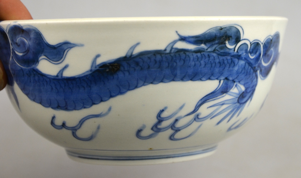 A Chinese 19th century heavily potted porcelain blue and white bowl decorated with a dragon - Image 4 of 5