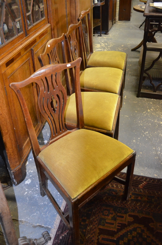 A set of four George III mahogany ear back side chairs having pierced vase shaped splats over drop-