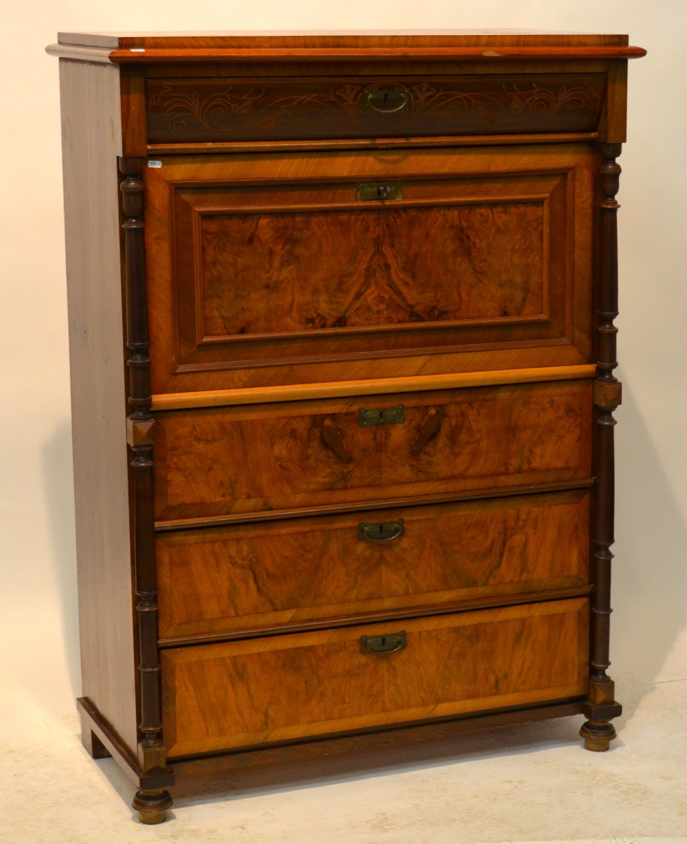 An early 20th century Continental walnut secretaire cabinet having a fitted drawer over three long