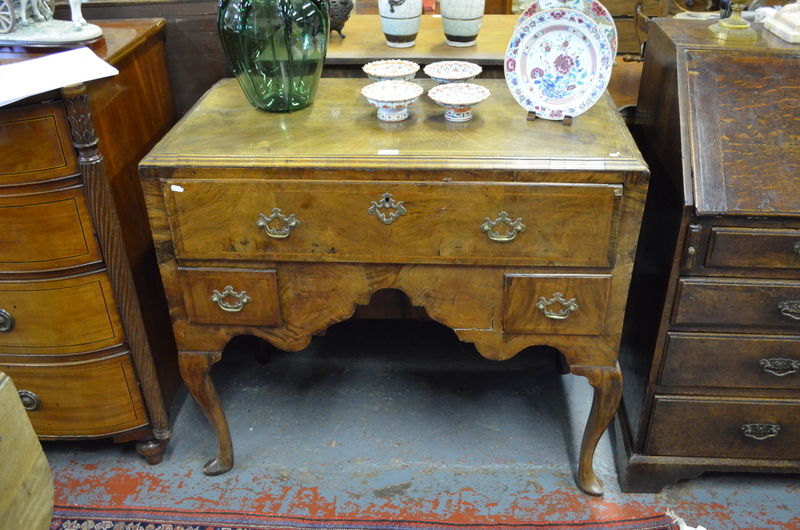 An 18th century featherbanded figured mahogany kneehole lowboy, the caddy top over a long deep
