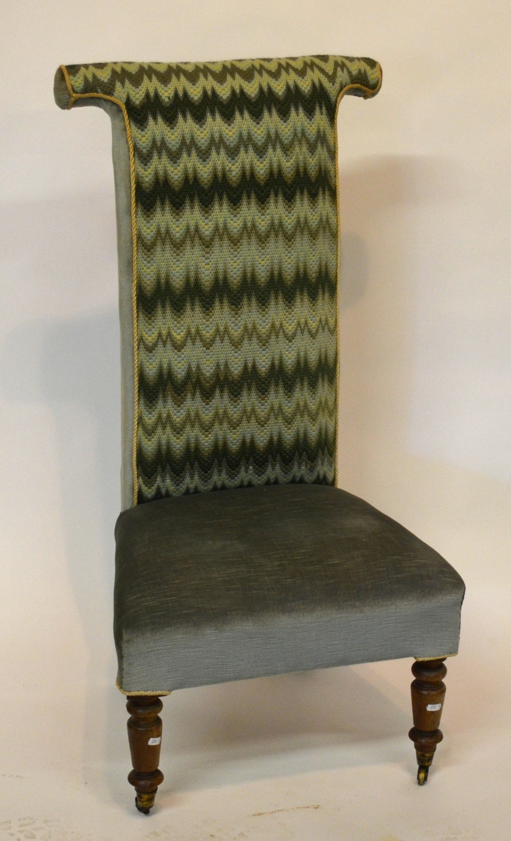 Victorian upholstered pre-dieu chair, raised on turned front legs on brass castors