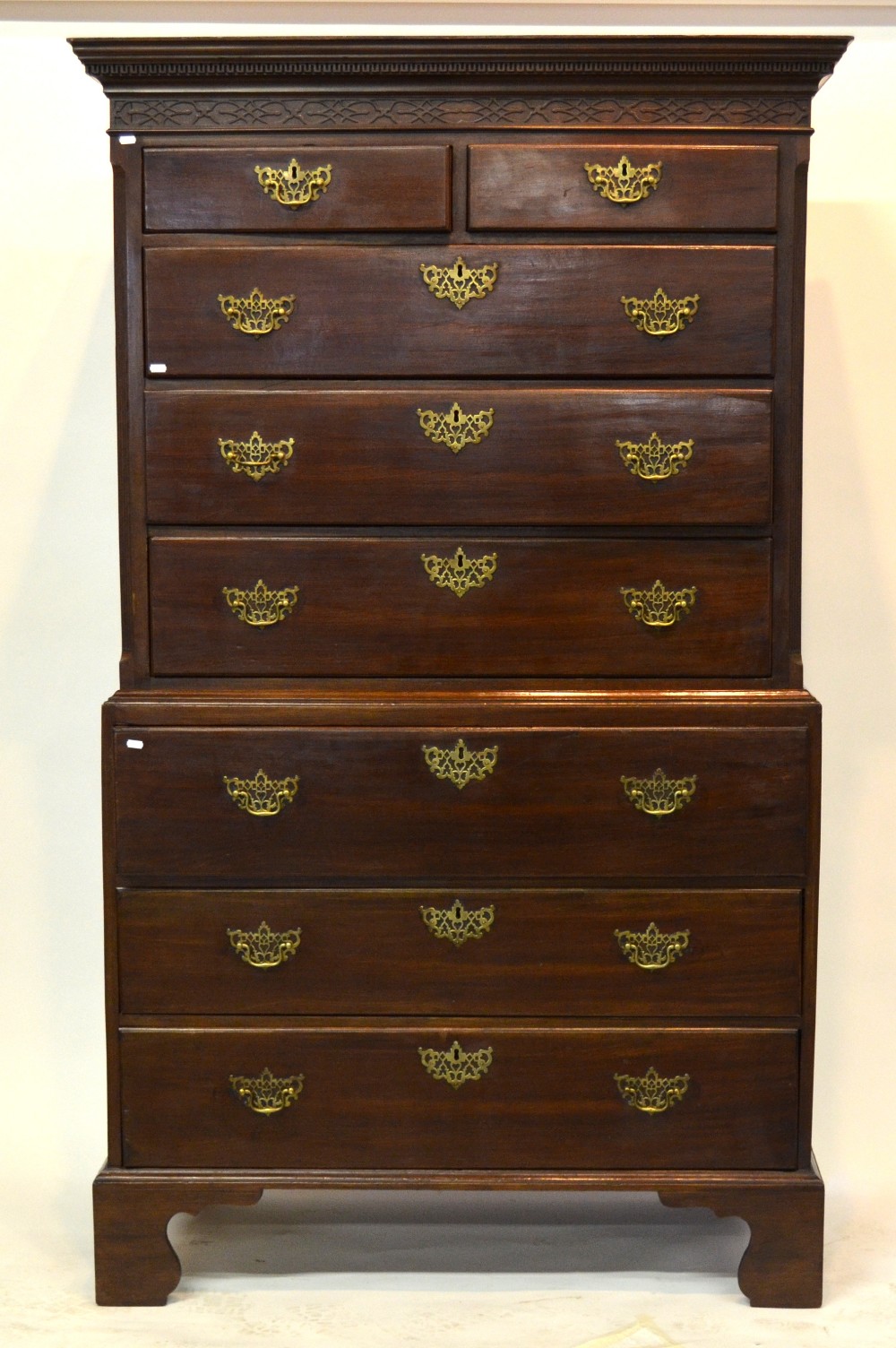 A George III mahogany secretaire chest on chest, the canopy with Greek key band over a relief