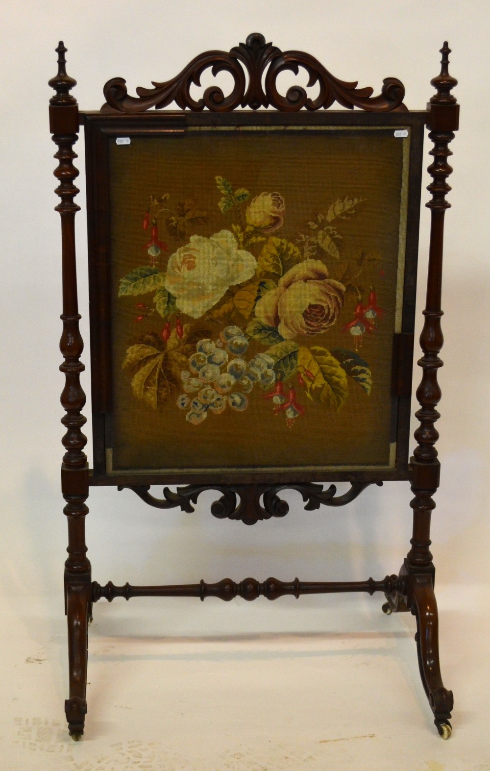 Victorian rosewood framed fire screen having a needlepoint panel under glass, flanked by turned