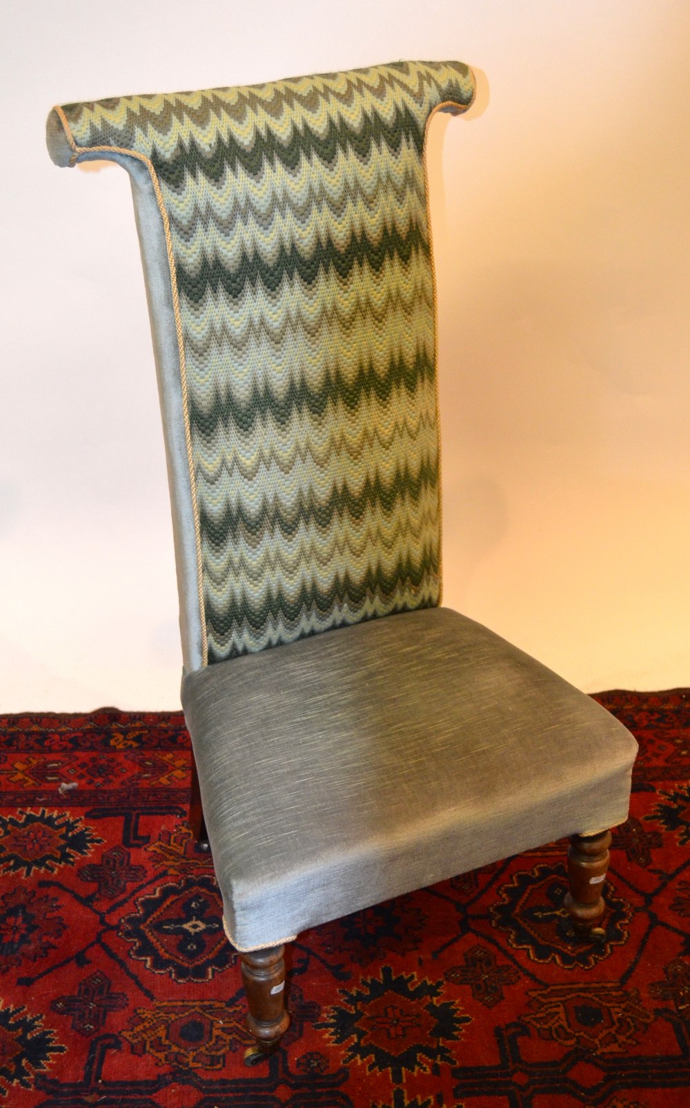 Victorian upholstered pre-dieu chair, raised on turned front legs on brass castors