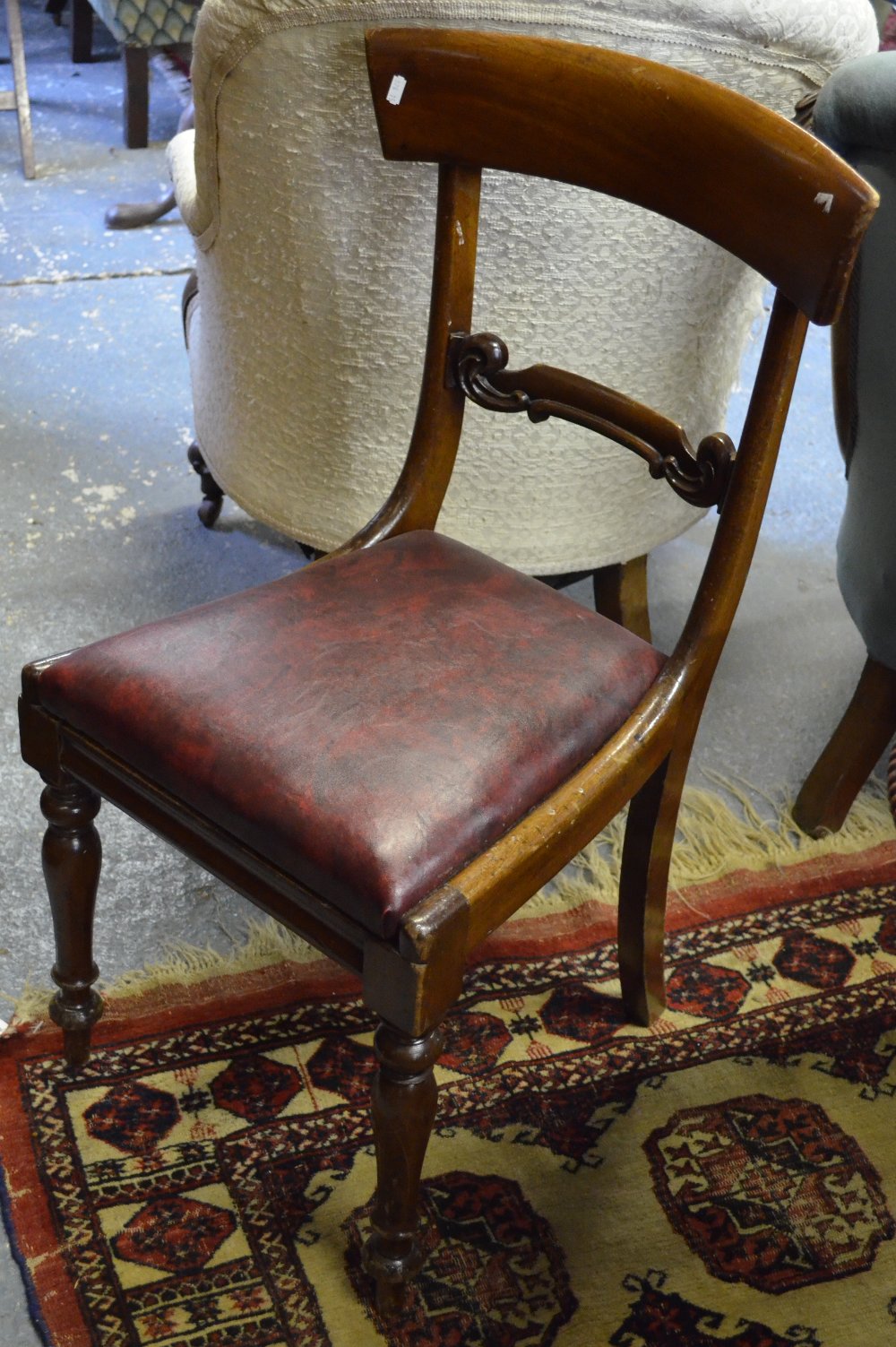 A harlequin set of five Victorian mahogany shaped bar-back chairs, each with matching red