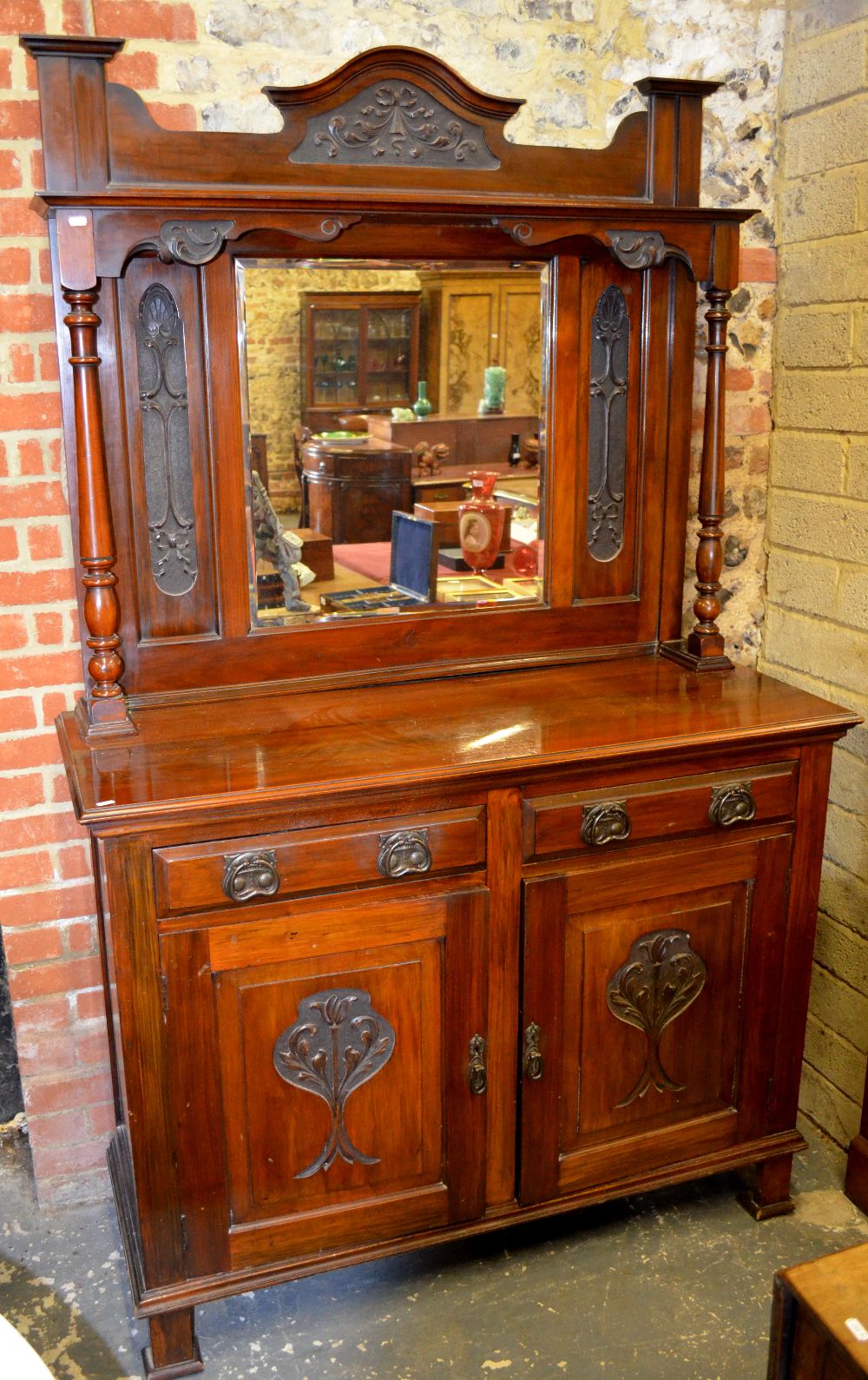 An Arts & Crafts period mirror-backed red walnut dresser having two frieze drawers over a pair of