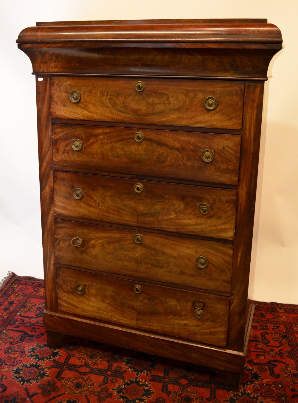 A 19th century continental chest of drawers, the shaped top having a cavetto drawer over five