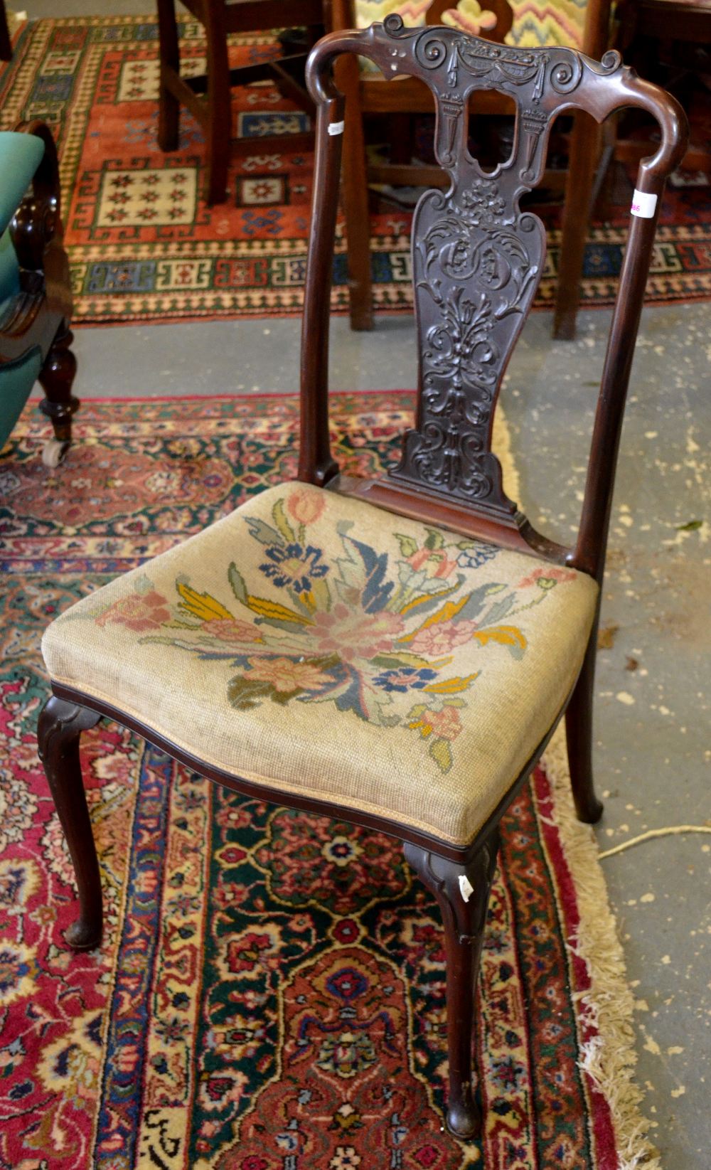 A Sheraton revival rosewood chair with elaborate relief carved vase shaped splat and overstuffed