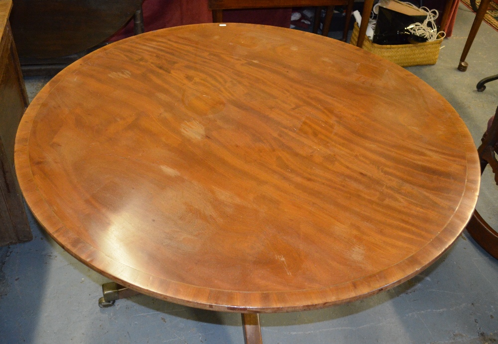 A Victorian mahogany breakfast table, the circular tilt top raised on a turned support on four