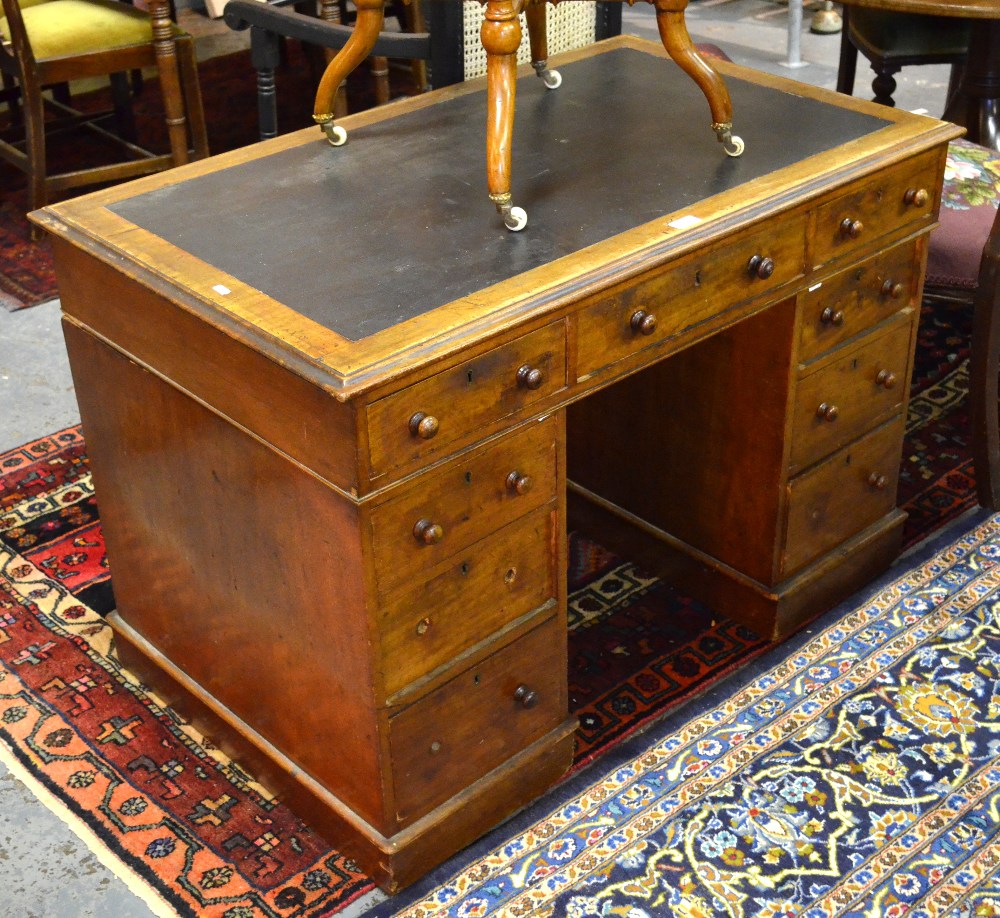 A Victorian mahogany pedestal desk, the top with leatherette surface over an arrangement of nine