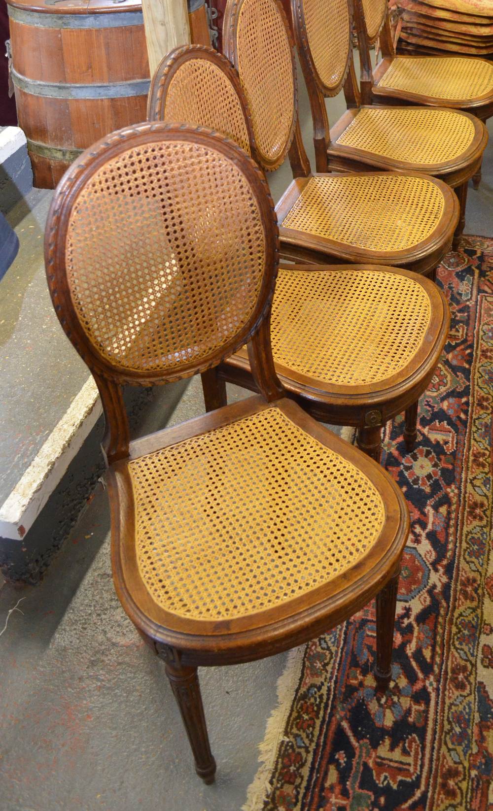 A set of six continental oak side chairs having caned oval panelled backs over conforming seats,