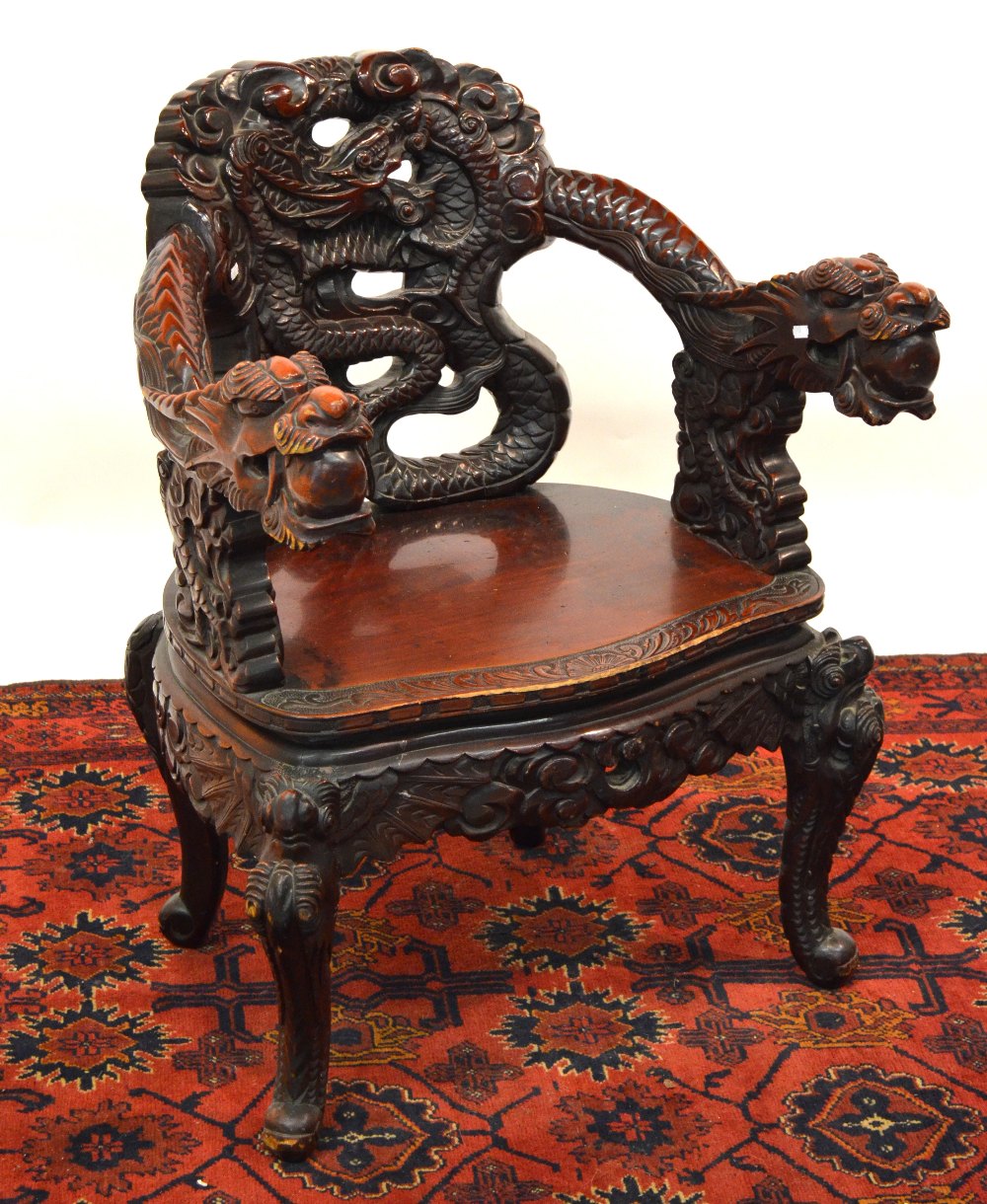 An antique Anglo-Chinese carved armchair, the pierced and carved scrolling dragon back having