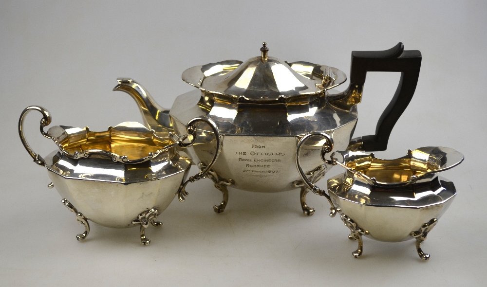 An Edwardian three-piece silver tea service with shaped rim and scroll feet, Goldsmiths &