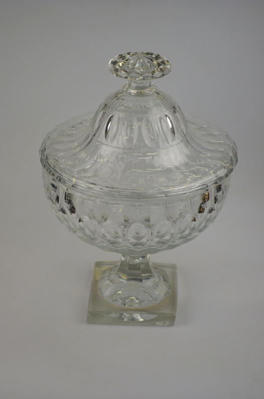 A garniture of three cut glass bowls and a cover cut overall with oval flutes, comprising a large
