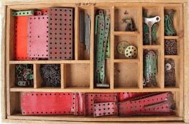 A Meccano set contained within a wooden box with sections and removable tray