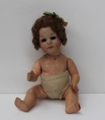A Heubach bisque head doll with open eyes with a composition body and arms, 18cm long