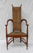 An Arts and Crafts oak and rush elbow chair, the back of rectangular form, the tapering seat on