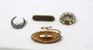 A yellow metal brooch of pointed oval form together with three other brooches