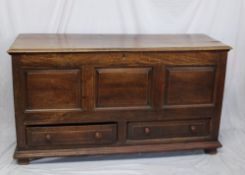 An 18th century oak coffer, the hinged planked rectangular top above a three panelled front and