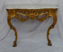 A marble topped console table of serpentine form, the base carved with leaves and swags 105cm wide x