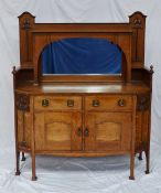 An Art Nouveau oak mirrorback sideboard, the back with a top shelf, a central mirror, with two
