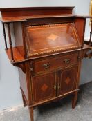An Arts and Crafts style bureau, with shelves, an inlaid sloping fall, a drawer and a pair of