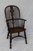 A Yew Windsor chair, with a hooped back with sticks and a pierced vase splat above a solid seat on