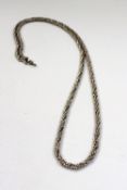 A long silver rope twist necklace together with another silver chain, a silver hinged bangle, a
