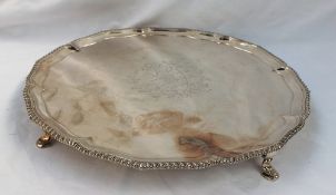 A George III silver salver with a gadrooned edge with a central crest with leaf surround, London,