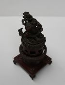 A Sino Tibetan bronze incense burner with Buddhist symbols with the deity Jambhala seated on top,