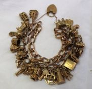 A 9ct yellow gold charm bracelet set with numerous charms including a Romany caravan, bible, cow,