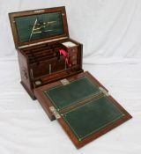 Am Edwardian oak travelling stationery box, the hinged top and front enclosing a fold down writing