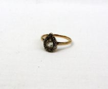 A diamond cluster ring the central pear shaped stone surrounded by old cut diamonds on a yellow