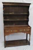 An 18th century style South Wales oak dresser, the moulded cornice above two shelves, the base