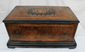 A walnut cased music box, the hinged top inlaid with a bouquet of flowers, with crossbanded sides,