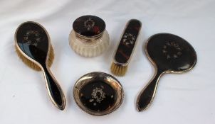 A silver and tortoiseshell matched part dressing table set comprising a hand mirror, hair brush,