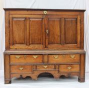 An 18th century oak mule chest, the planked top now fixed above a pair of panelled doors, the base
