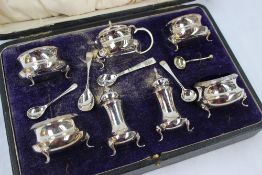 A George V silver seven piece cruet set including open table salts, pepperettes, Mustard pot etc,